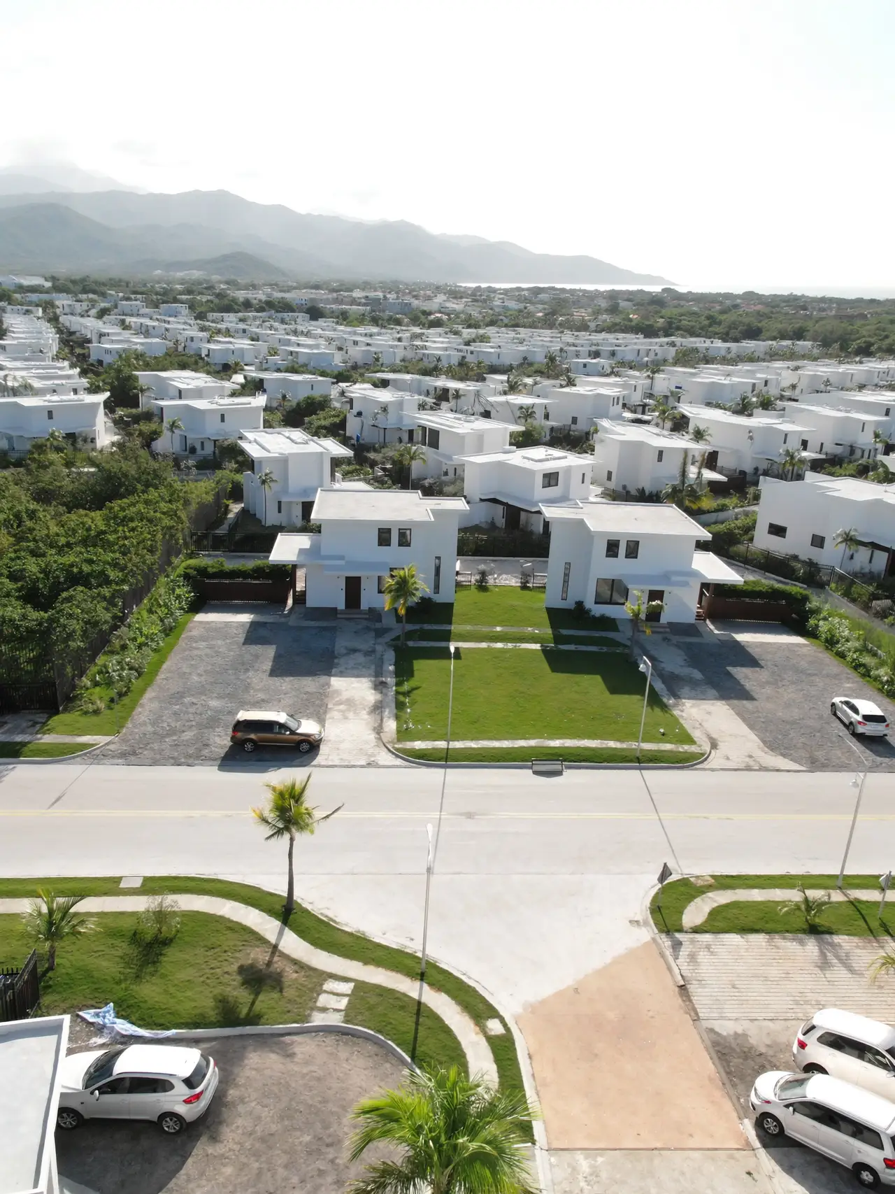 An aerial view of a residential community with new streets and mountains behind