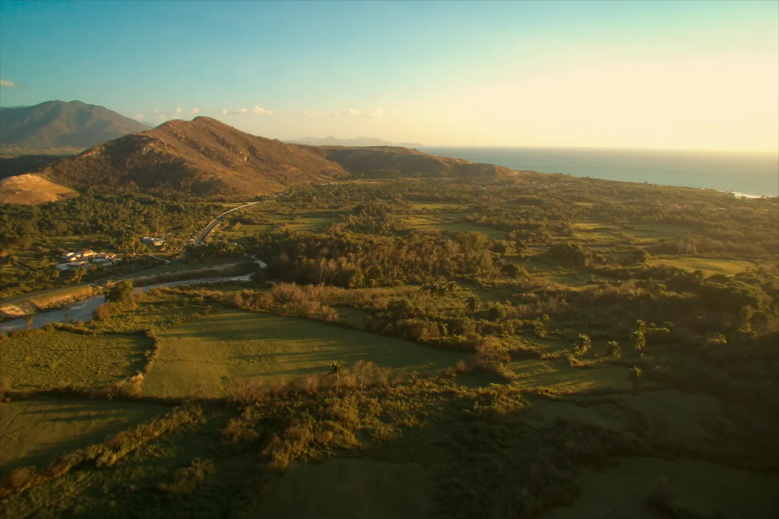 Aerial view of the area: mountains, farmland, the highway and the Caribbean sea beyond